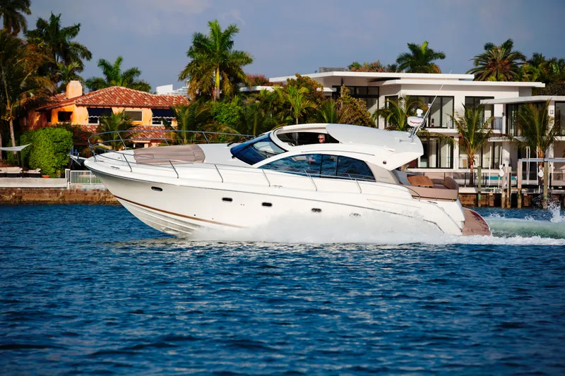 Slide: The Image of Luxury 2012 Prestige 440S yacht cruising near waterfront homes and palm trees. - 8
