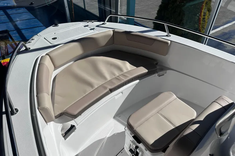 Slide: The Image of 2026 Edgewater 188CC boat interior with beige cushioned seating in sunlight. - 12