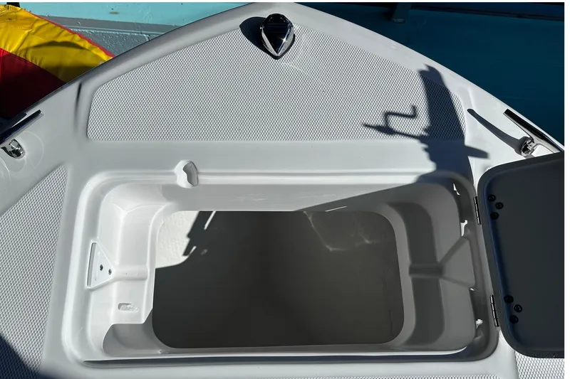 Slide: The Image of Open storage compartment on 2026 Edgewater 188CC boat, featuring a sleek white interior. - 16