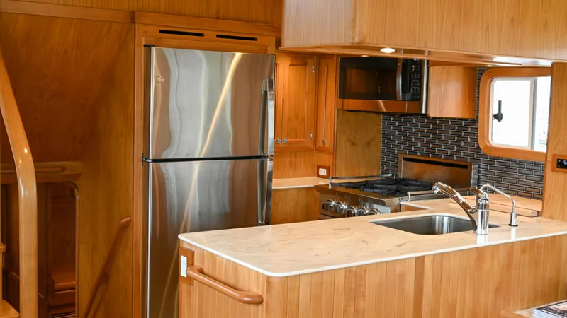 Slide: The Image of Modern kitchen in 2025 Krogen 44 AE yacht with stainless steel appliances and wooden cabinetry. - 2