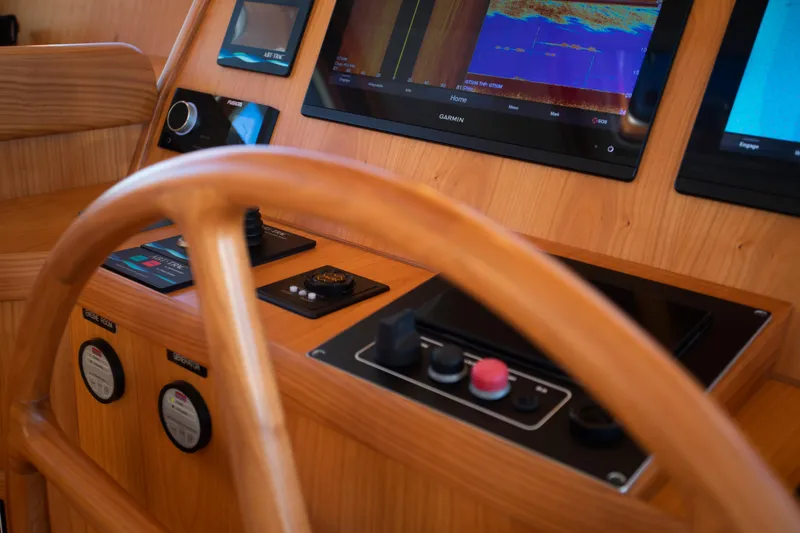 Slide: The Image of Krogen 48 AE 2025 yacht helm with advanced navigation systems and wooden steering wheel. - 4