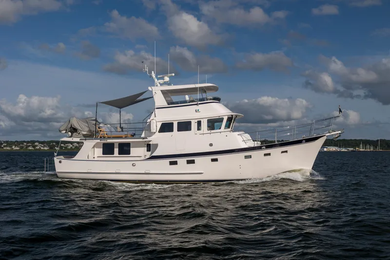 The Image of 2026 Krogen 58 Extended Bridge yacht cruising on open water under a cloudy sky. - 0