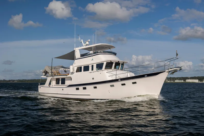 Slide: The Image of 2026 Krogen 58 Extended Bridge yacht cruising on open water under a partly cloudy sky. - 14