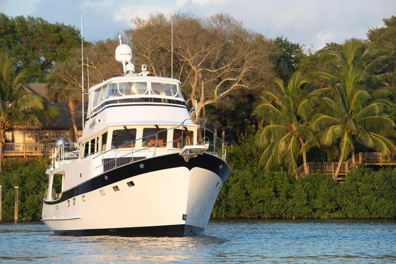 Slide: The Image of 2025 Krogen 58 Extended Bridge yacht on serene water, surrounded by lush greenery. - 32