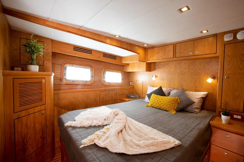 Slide: The Image of Luxurious bedroom in 2025 Krogen 52 yacht with wooden interior and cozy bedding. - 10
