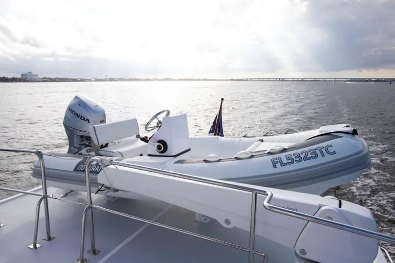 Slide: The Image of Krogen 52 yacht (2025) with a Honda-powered dinghy on deck, cruising on open water. - 16