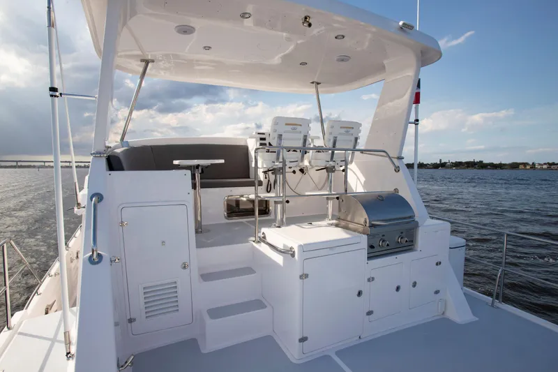 Slide: The Image of 2025 Krogen 52 yacht flybridge with seating and grill, overlooking calm waters. - 2