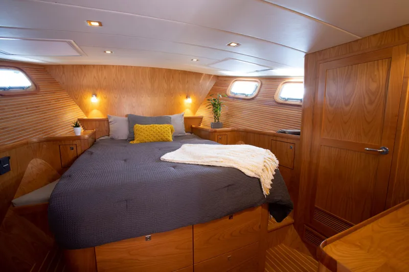 Slide: The Image of Luxurious master cabin in 2025 Krogen 52 yacht with wood paneling and cozy bedding. - 9