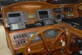 Slide: The Image of 2004 Ocean Alexander 548 Pilothouse helm with navigation instruments and wooden steering wheel. - 12