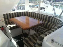 Slide: The Image of 2004 Ocean Alexander 548 Pilothouse interior with striped seating and wooden table. - 26