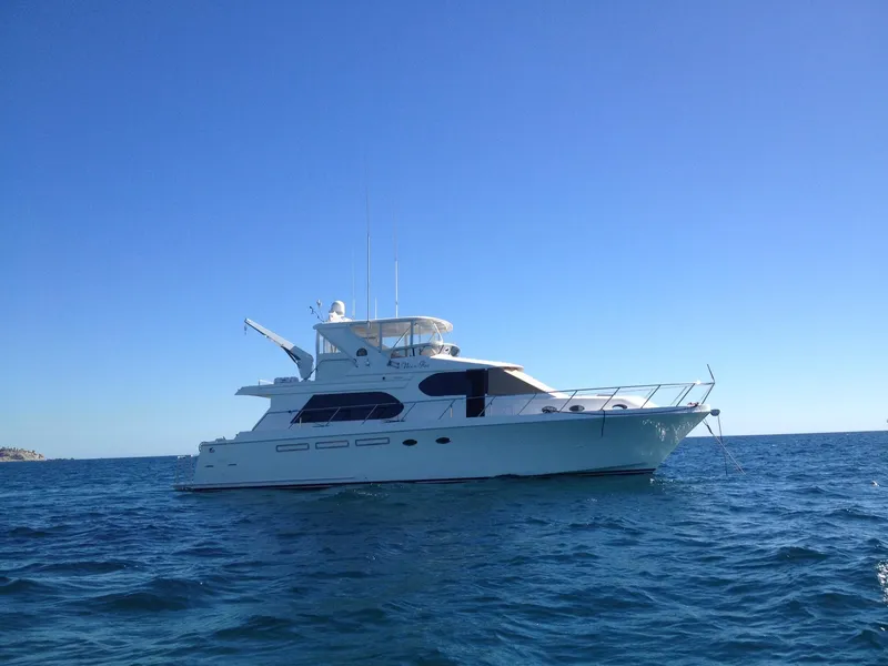 Slide: The Image of 2004 Ocean Alexander 548 Pilothouse yacht on open water under clear blue sky. - 5
