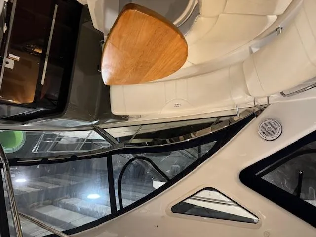 Slide: The Image of Interior of a 2008 Regal 3760 yacht with white seating and wooden table. - 16