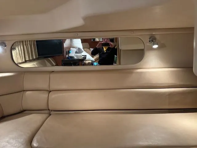 Slide: The Image of Interior of a 2008 Regal 3760 yacht with beige leather seating and a mirror. - 26