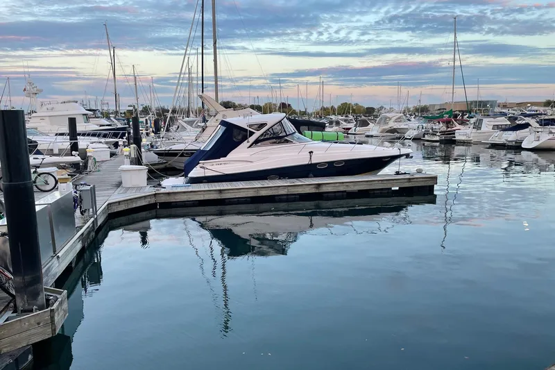 Slide: The Image of 2008 Regal 3760 yacht docked at a marina with calm waters and a scenic sky. - 3