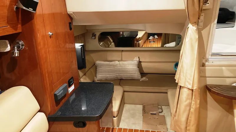 Slide: The Image of 2008 Regal 3760 yacht interior with beige seating, wooden cabinetry, and a small kitchenette. - 37