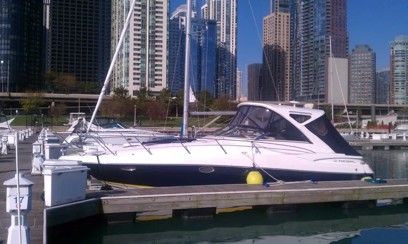 Slide: The Image of 2008 Regal 3760 yacht docked in a marina with city skyline in the background. - 6