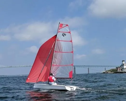 The Image of 2026 Beneteau First 14 sailboat on open water with red sails. - 1