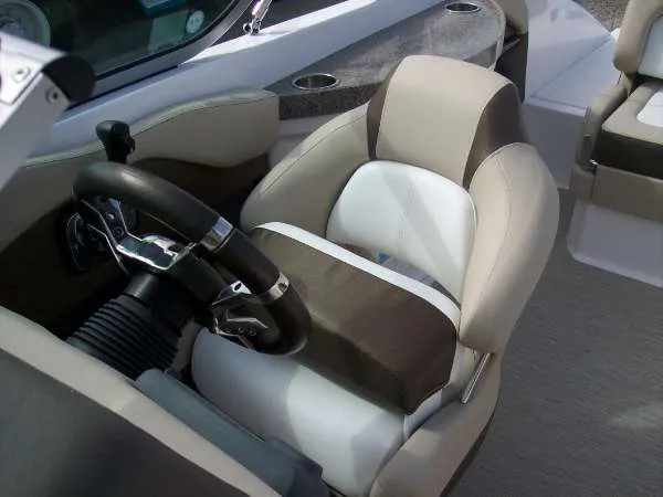 Slide: The Image of 2014 Regal 24 FasDeck boat interior with steering wheel and cushioned seating. - 15