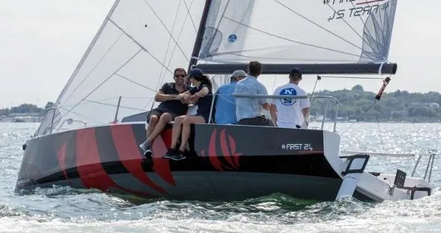 The Image of 2026 Beneteau First 24 sailboat with crew sailing on open water. - 1