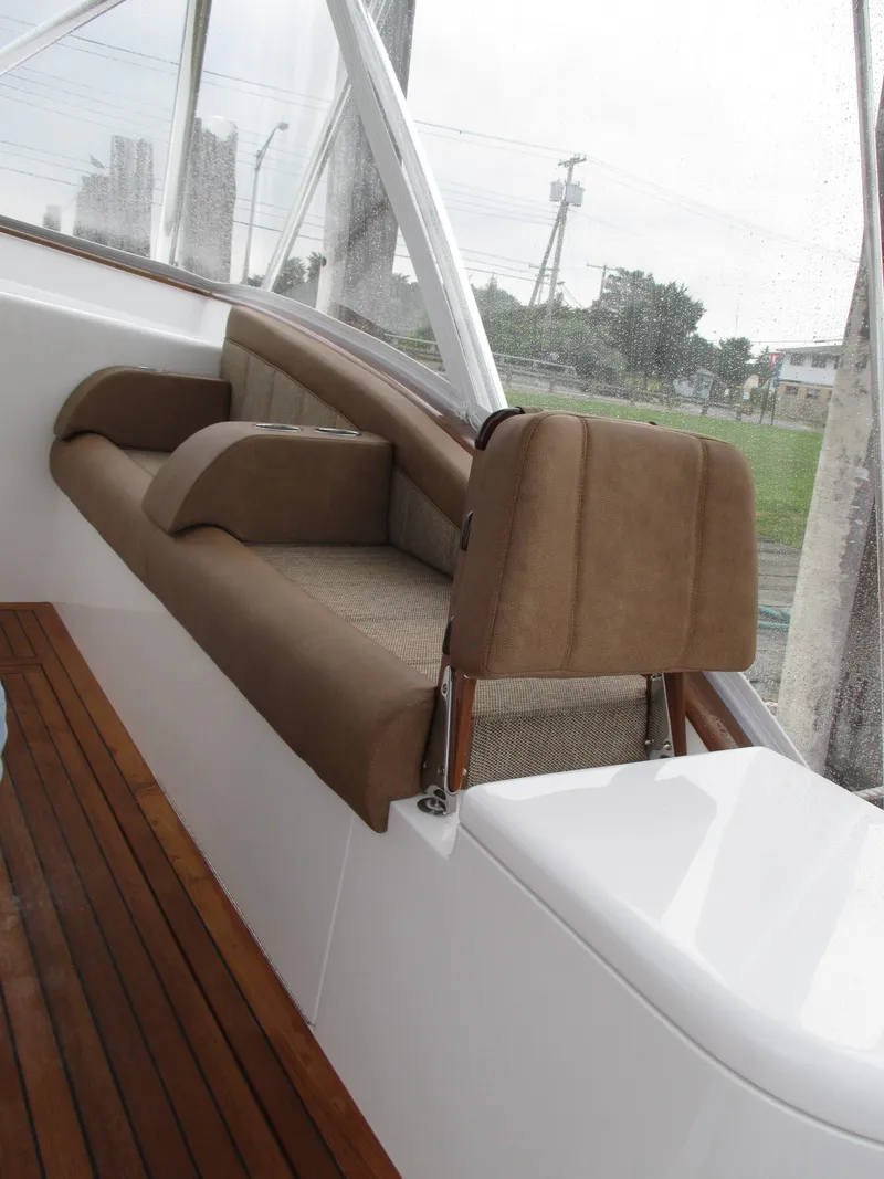 Slide: The Image of 2024 Jersey Cape Devil 36 Custom boat interior with brown seating and wooden flooring. - 32
