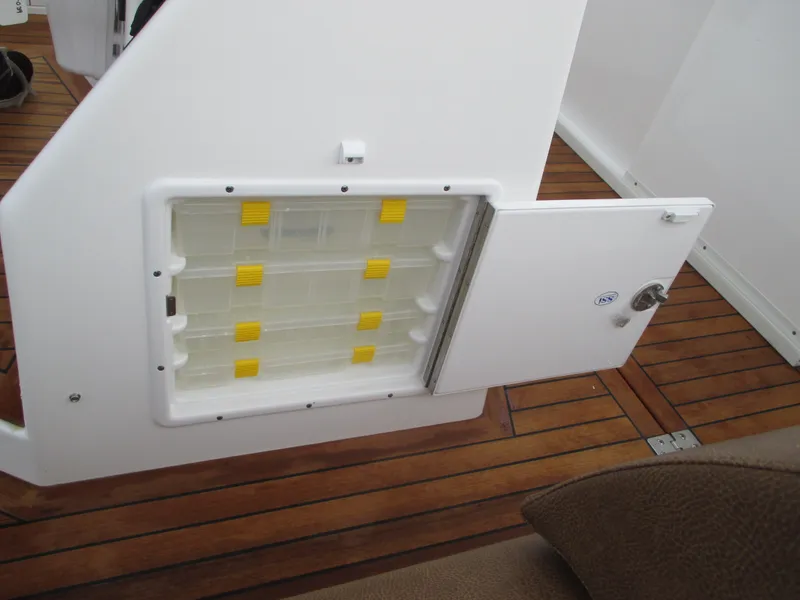 Slide: The Image of Jersey Cape Devil 36 Custom 2024 storage compartment with yellow latches on wooden deck. - 39