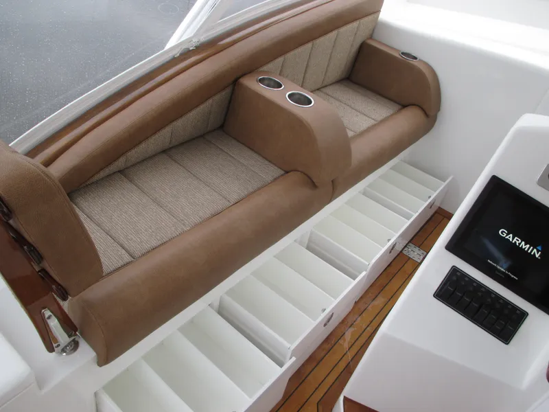 Slide: The Image of Jersey Cape Devil 36 Custom 2024 interior seating with storage compartments and Garmin display. - 43