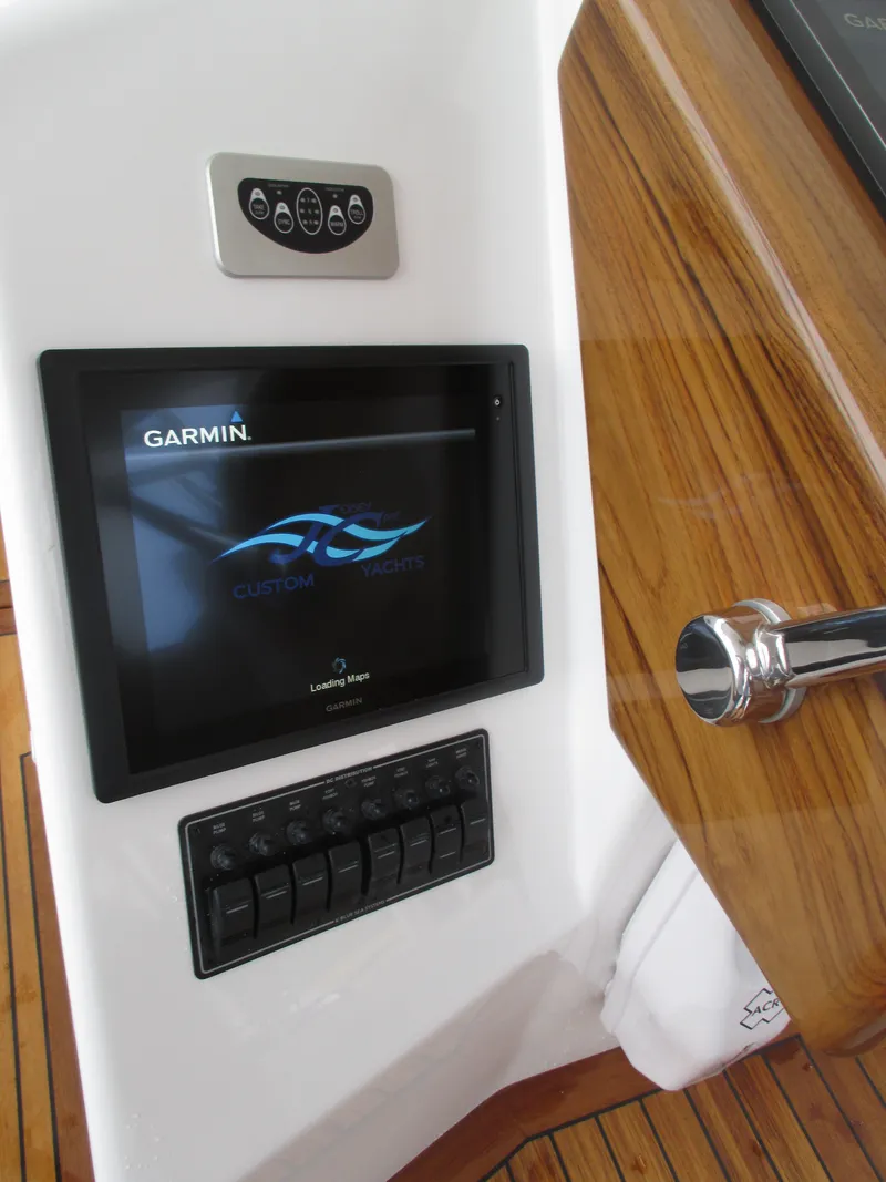Slide: The Image of 2024 Jersey Cape Devil 36 Custom boat dashboard with Garmin display and control panel. - 44