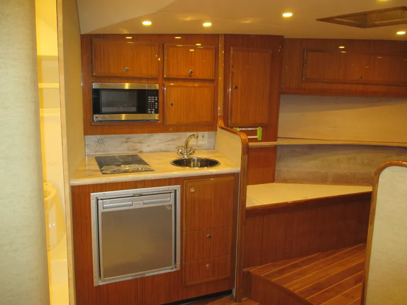 Slide: The Image of 2024 Jersey Cape Devil 36 Custom yacht interior kitchen with wood cabinetry and modern appliances. - 7