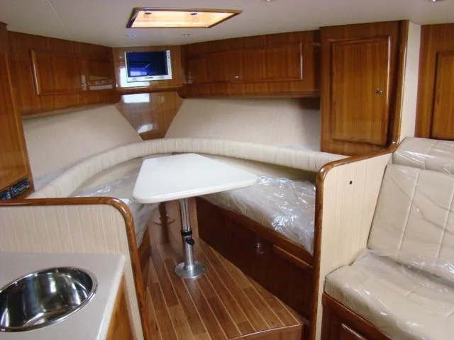 Slide: The Image of 2024 Jersey Cape Devil 36 Custom cabin interior with wood finish and seating area. - 8