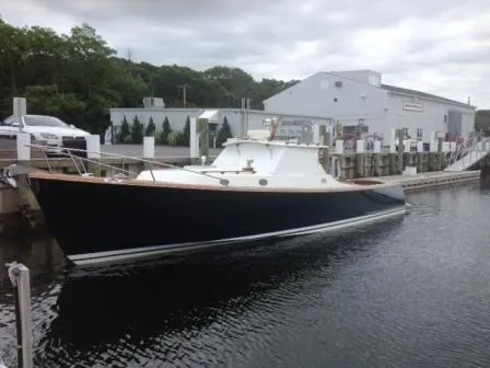 The Image of Classic Coaster 1999 Picnic Boat docked at marina, overcast sky. - 0