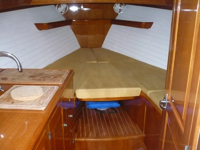Slide: The Image of Interior of a 1999 Classic Coaster Picnic Boat with wooden cabinetry and cozy sleeping area. - 13