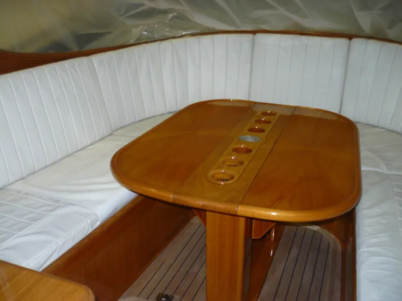 Slide: The Image of Interior of 1999 Classic Coaster Picnic Boat with wooden table and white cushioned seating. - 15