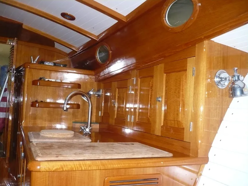 Slide: The Image of Interior of 1999 Classic Coaster Picnic Boat with polished wood cabinetry and stainless steel fixtures. - 21