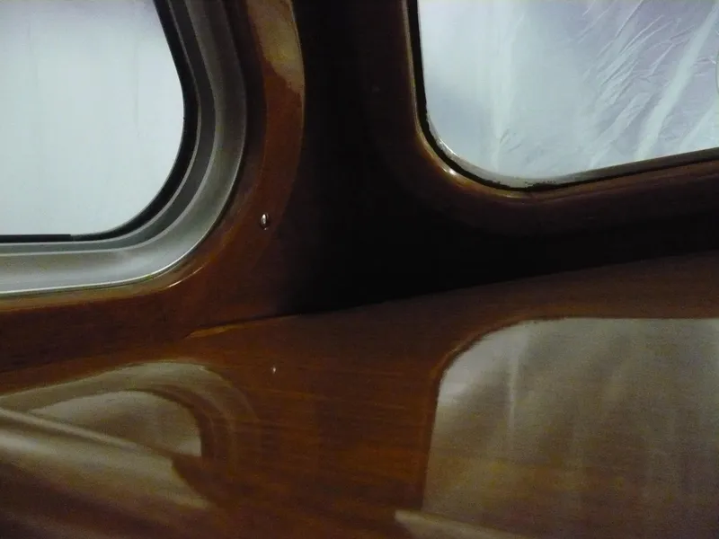 Slide: The Image of Interior view of a 1999 Classic Coaster Picnic Boat with polished wood finish. - 27