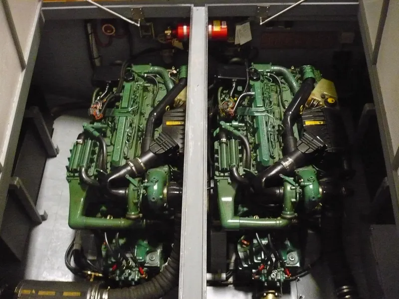 Slide: The Image of Engine compartment of a 1999 Classic Coaster Picnic Boat, featuring dual green engines. - 31