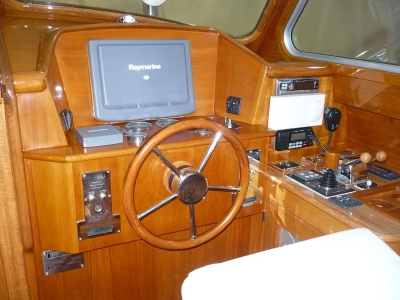 Slide: The Image of 1999 Classic Coaster Picnic Boat helm with wooden steering wheel and navigation equipment. - 5