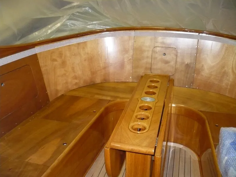 Slide: The Image of Interior of a 1999 Classic Coaster Picnic Boat with polished wooden seating and table. - 6