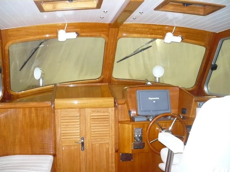 Slide: The Image of Interior of a 1999 Classic Coaster Picnic Boat with wooden dashboard and steering wheel. - 7