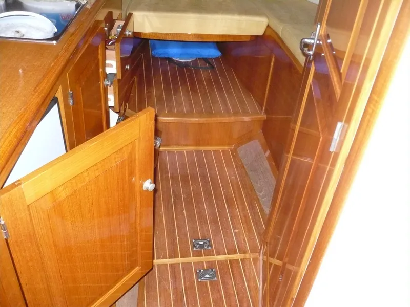 Slide: The Image of Interior of 1999 Classic Coaster Picnic Boat with wooden flooring and open cabinet. - 8