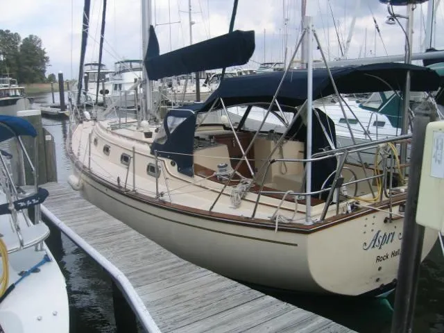 The Image of 1989 Island Packet 35 sailboat docked at marina with blue canopy. - 0