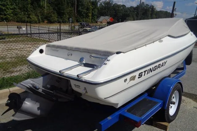 Slide: The Image of 2005 Stingray 180RX boat on trailer, covered and parked outdoors. - 2