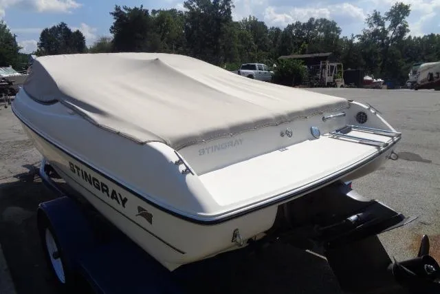 Slide: The Image of 2005 Stingray 180RX boat with cover, parked outdoors on a trailer. - 3