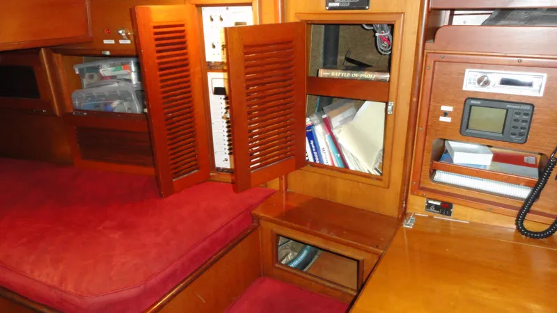 Slide: The Image of Interior of 1980 Hinckley 43 sailboat with wooden cabinetry and red cushions. - 26