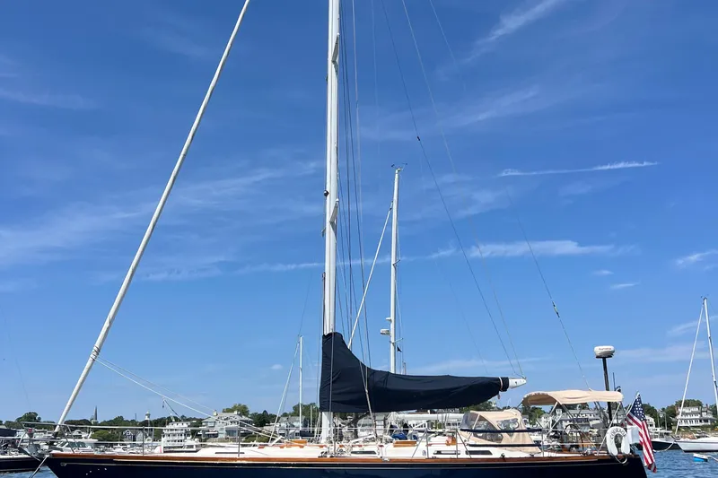 Slide: The Image of 1980 Hinckley 43 sailboat docked under clear blue sky. - 58
