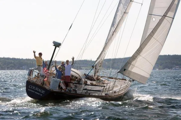 Slide: The Image of Sailing on a 1980 Hinckley 43 yacht named "Courage" with people waving. - 13