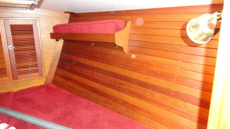 Slide: The Image of Interior of 1980 Hinckley 43 yacht with wooden paneling and red upholstery. - 17