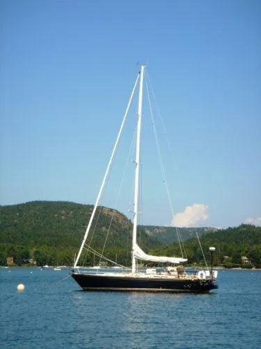 Slide: The Image of 1980 Hinckley 43 sailboat on calm water with scenic mountain backdrop. - 18