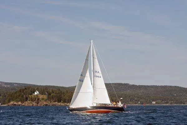 Slide: The Image of 1980 Hinckley 43 sailboat cruising on a scenic lake with forested hills in the background. - 20