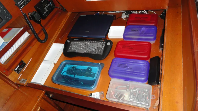 Slide: The Image of Organized navigation station on 1980 Hinckley 43 yacht with laptop and storage containers. - 27