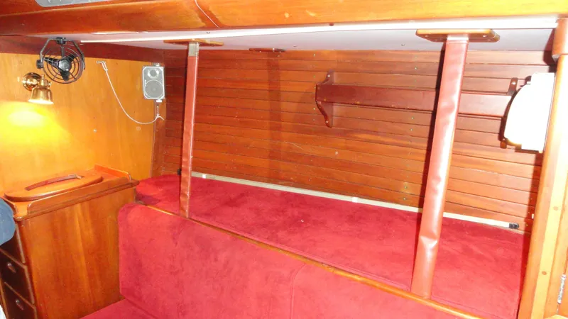 Slide: The Image of Interior of 1980 Hinckley 43 yacht with red seating and wooden paneling. - 32